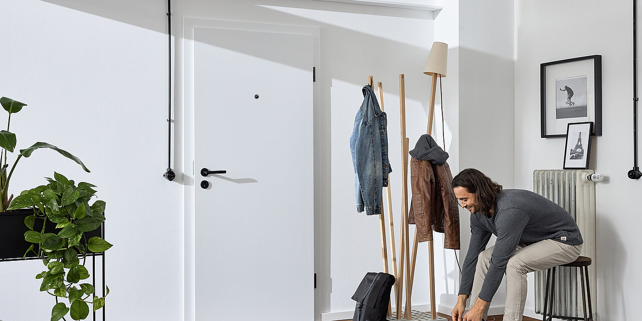 Schöner Flur im industriellen Stil mit weißer Wohnungseingangstür