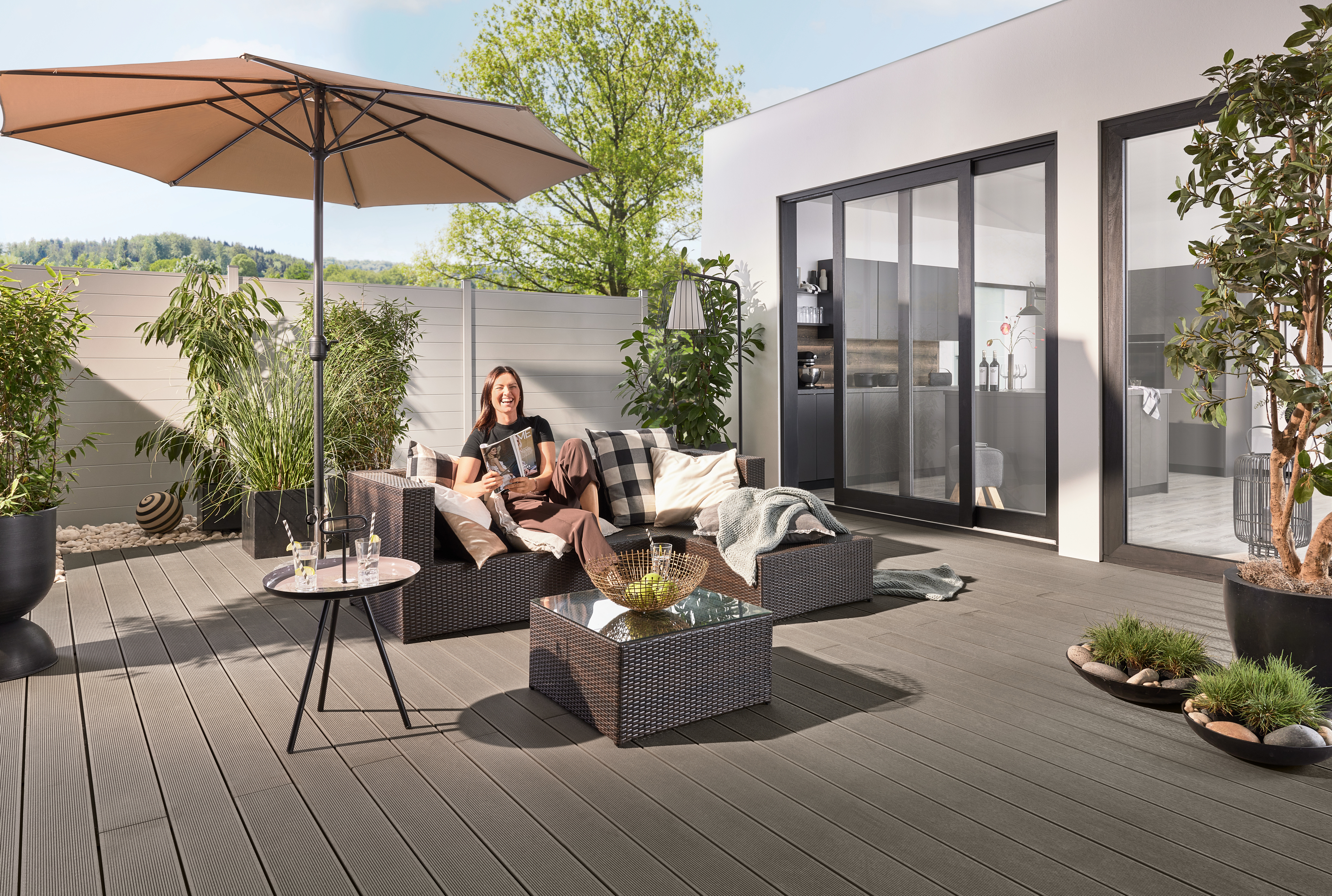 Lachende glückliche Frau auf einer modernen Terrasse