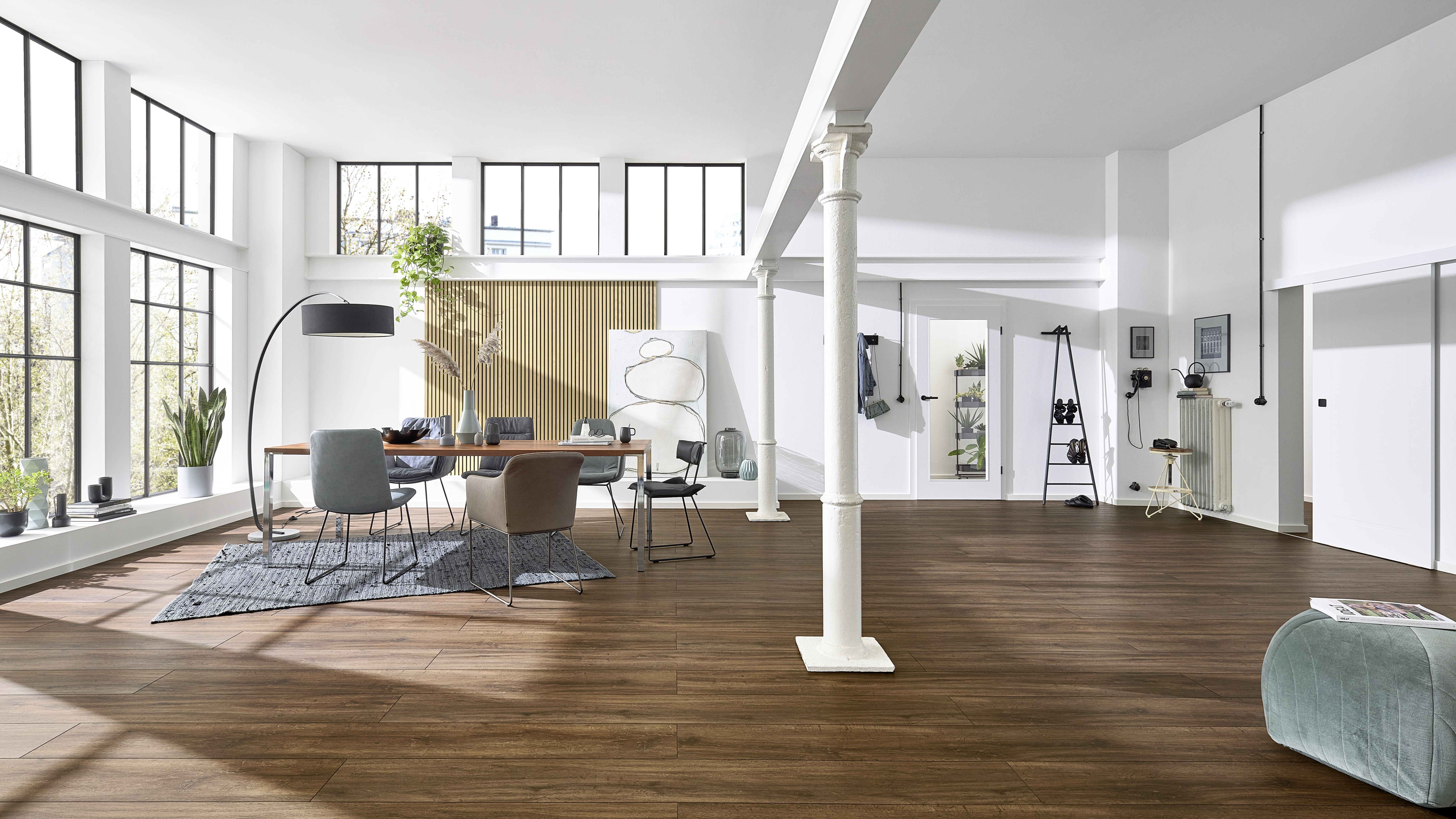 Esszimmer in einer Loftwohnung mit dunklem Boden und modernen Akustikpaneelen